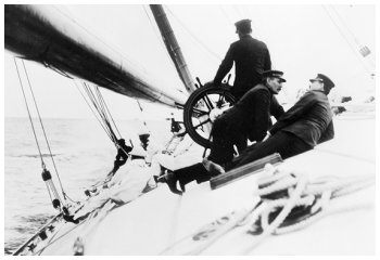 This photograph shows the crew lying on board the tilting deck of the Reliance, 1903 - A winch in the foreground.